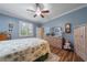 Charming bedroom with a ceiling fan, decorative mirror and floral bedding at 9839 Nostalgia Pl, Englewood, FL 34223
