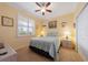 Cozy bedroom featuring a ceiling fan, bedside lamps, and window with shutters at 9839 Nostalgia Pl, Englewood, FL 34223