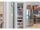 Pantry showcasing organized shelving, stainless steel refrigerator and additional kitchen space at 9839 Nostalgia Pl, Englewood, FL 34223