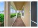 Covered front porch with brick flooring and white railings, providing a welcoming entrance at 9839 Nostalgia Pl, Englewood, FL 34223
