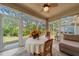 Bright sunroom with multiple windows, tile floors, ceiling fan, and casual seating area with outdoor views at 9839 Nostalgia Pl, Englewood, FL 34223