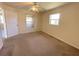 Cozy bedroom with carpet, neutral paint, two windows offering natural light, and a ceiling fan at 1032 Mohawk Rd, Venice, FL 34293