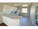 Well-lit kitchen with white cabinets, countertops, modern appliances, and tiled floors at 1032 Mohawk Rd, Venice, FL 34293