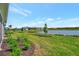 Well-manicured backyard with a peaceful lake view and lush, green lawn at 10399 Abaco Falls Dr, Englewood, FL 34223