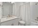 Bathroom with a single vanity, a large mirror, a toilet, and a shower with a white shower curtain at 10399 Abaco Falls Dr, Englewood, FL 34223