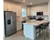 Spacious kitchen with stainless steel appliances, white cabinets, and an island with barstool seating at 10399 Abaco Falls Dr, Englewood, FL 34223