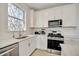 Bright kitchen features stainless steel appliances, white cabinets and countertops, and a stained glass window at 10399 Abaco Falls Dr, Englewood, FL 34223
