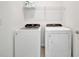 Bright laundry room featuring a Whirlpool washer and dryer with a storage shelf above at 10399 Abaco Falls Dr, Englewood, FL 34223
