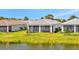 Rear view of home featuring screened lanai and landscaped backyard at 10399 Abaco Falls Dr, Englewood, FL 34223