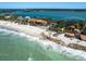Breathtaking aerial shot of a luxury beachfront property with clear turquoise waters and sandy shore at 1049 N Casey Key Rd, Osprey, FL 34229