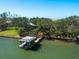 Aerial view of a house with a boat lift and trees surrounding the property at 1049 N Casey Key Rd, Osprey, FL 34229