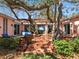 Charming backyard patio with seating, surrounded by mature trees, offering a tranquil space for outdoor enjoyment at 1049 N Casey Key Rd, Osprey, FL 34229