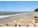 Beautiful beachfront property with waves crashing along a sandy shore under clear blue skies at 1049 N Casey Key Rd, Osprey, FL 34229