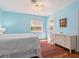 This bedroom offers ample sunlight, terracotta tile, a queen-sized bed and a white dresser at 1049 N Casey Key Rd, Osprey, FL 34229