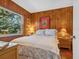 Cozy bedroom with wood paneling, queen size bed and a sunlit window at 1049 N Casey Key Rd, Osprey, FL 34229