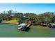 Exterior shot of a boat lift on a sunny day with lush tropical trees in the background at 1049 N Casey Key Rd, Osprey, FL 34229