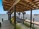 Boat lift featuring a boat, a yellow hose and wooden supports and walkway at 1049 N Casey Key Rd, Osprey, FL 34229