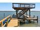 Boat lift with wooden structure and stairs with a boat underneath at 1049 N Casey Key Rd, Osprey, FL 34229
