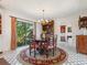 Charming dining room featuring a round table, hardwood chairs, and views of the backyard through a large window at 1049 N Casey Key Rd, Osprey, FL 34229