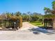 View of driveway lined with lush, mature landscaping leading to a private estate with security gates at 1049 N Casey Key Rd, Osprey, FL 34229