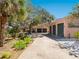 Charming home with three-car garage featuring lush landscaping, a mature tree, and a serene atmosphere at 1049 N Casey Key Rd, Osprey, FL 34229
