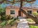 Inviting exterior with beautiful landscaping featuring a brick walkway leading to a charming arched doorway at 1049 N Casey Key Rd, Osprey, FL 34229
