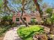 Charming home with a tile roof, complemented by a lush, landscaped yard and a winding brick walkway at 1049 N Casey Key Rd, Osprey, FL 34229