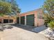 A three-car garage with dark green doors in a unique detached building near the main house at 1049 N Casey Key Rd, Osprey, FL 34229