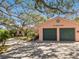 Charming home exterior featuring garage, lush landscaping and mature trees at 1049 N Casey Key Rd, Osprey, FL 34229
