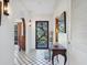 Inviting hallway with arched doorways, white walls, patterned tile flooring, and a glimpse of the outdoors at 1049 N Casey Key Rd, Osprey, FL 34229
