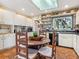 Bright kitchen features white cabinets, black countertops, terracotta floors, and a round table with seating at 1049 N Casey Key Rd, Osprey, FL 34229