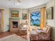 Cozy living room with fireplace, comfortable seating, and a large window showcasing serene waterfront views at 1049 N Casey Key Rd, Osprey, FL 34229