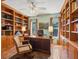 Traditional office features built-in bookshelves, hardwood floors, and two large windows with outdoor views at 1049 N Casey Key Rd, Osprey, FL 34229