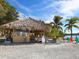 Charming tiki hut with thatched roof, colorful chairs, and waterfront views at 1049 N Casey Key Rd, Osprey, FL 34229