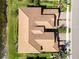 Overhead view of townhome complex featuring terracotta tile roofs, garages, and lush landscaping along a lake at 10797 Tarflower Dr # 202, Venice, FL 34293