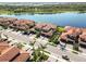 Wide aerial shot of a townhome community with terracotta roofs, palm trees, and lake views at 10797 Tarflower Dr # 202, Venice, FL 34293