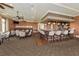 An elegant bar area featuring a wooden bar with stools, tables with chairs, and a stocked bar for gatherings at 10797 Tarflower Dr # 202, Venice, FL 34293