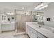 Elegant bathroom featuring glass-enclosed shower, dual vanities, and a bright, airy atmosphere at 10797 Tarflower Dr # 202, Venice, FL 34293