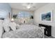 Bedroom boasts a plank accent wall with neutral decor, a white dresser, and natural light at 10797 Tarflower Dr # 202, Venice, FL 34293