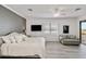 Bedroom with plank accent wall, large window, and a light gray striped couch overlooking lake at 10797 Tarflower Dr # 202, Venice, FL 34293