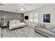 Bedroom boasts an en-suite seating area, plank accent wall, and large windows with plantation shutters at 10797 Tarflower Dr # 202, Venice, FL 34293