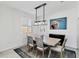 Sunlit dining room with a modern light fixture and a picturesque heron painting at 10797 Tarflower Dr # 202, Venice, FL 34293