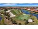Aerial view of a beautiful golf course with sand traps, palm trees, green fairways, and waterfront houses at 10797 Tarflower Dr # 202, Venice, FL 34293