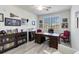 Office with a built-in bookcase, wooden desk, two mauve accent chairs, and natural light at 10797 Tarflower Dr # 202, Venice, FL 34293