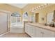 Bright bathroom featuring a garden tub, vanity with dual sinks, and a separate shower at 108 Corte Del Asolo, Venice, FL 34285