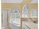 Bright bathroom featuring a garden tub, vanity with dual sinks, and a separate shower at 108 Corte Del Asolo, Venice, FL 34285