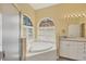 Bright bathroom featuring a garden tub, vanity with dual sinks, and a separate shower at 108 Corte Del Asolo, Venice, FL 34285