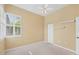 Bedroom featuring carpeted floors, a window with plantation shutters, and a ceiling fan at 108 Corte Del Asolo, Venice, FL 34285
