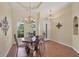 Cozy dining room featuring a chandelier, a dining set, and a tray ceiling above warm laminate flooring at 108 Corte Del Asolo, Venice, FL 34285