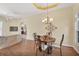 Open-concept dining room adjacent to living area, featuring elegant decor and laminate flooring at 108 Corte Del Asolo, Venice, FL 34285